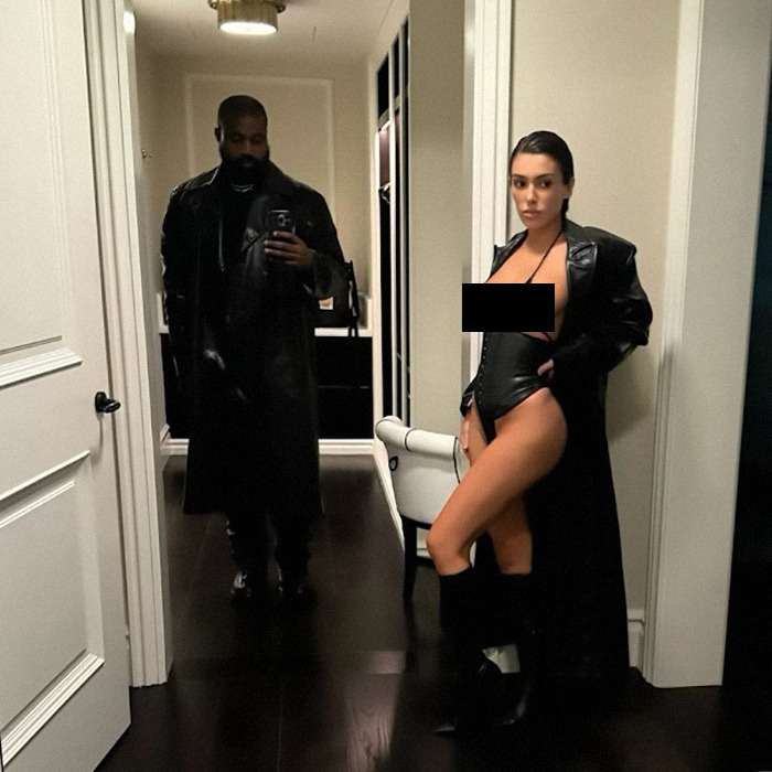 Man in black coat takes mirror selfie with woman in revealing outfit, fits Kanye West AI meme keyword theme.