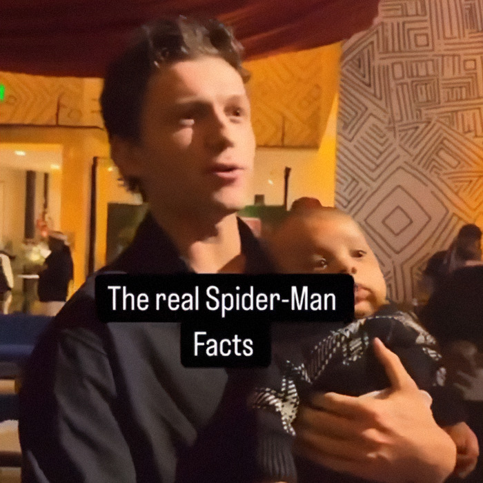 Man holding a baby at a family gathering, with text overlay about Spider-Man facts.