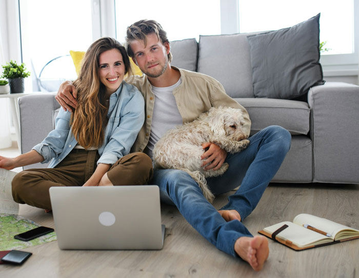 Man with partner and dog, sitting on floor, expressing emotions about in-laws and wedding cancellation.