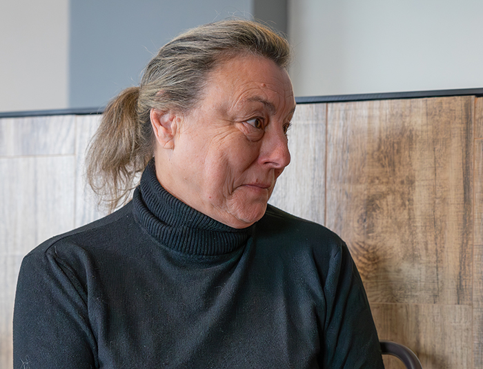 A woman in a black turtleneck looking concerned, related to a public allergy incident.