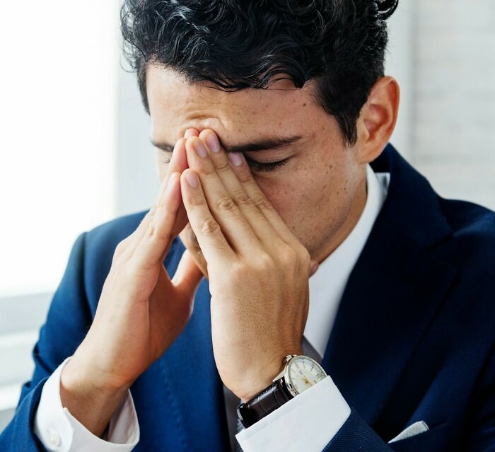 Man in blue suit appearing stressed, possibly reacting to a wedding objection.