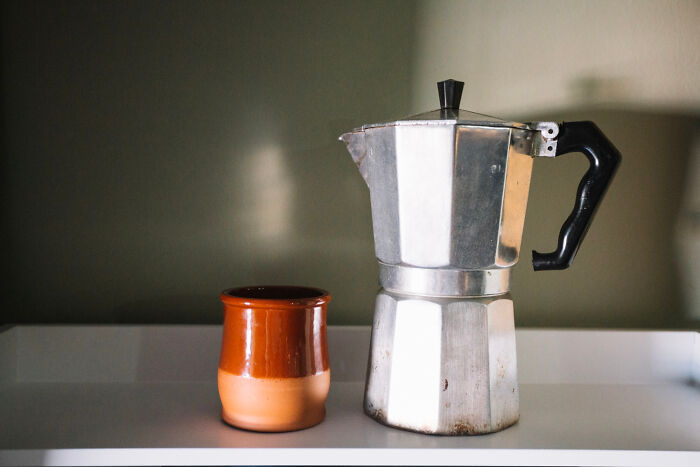 Affordable stovetop espresso maker with a ceramic mug.