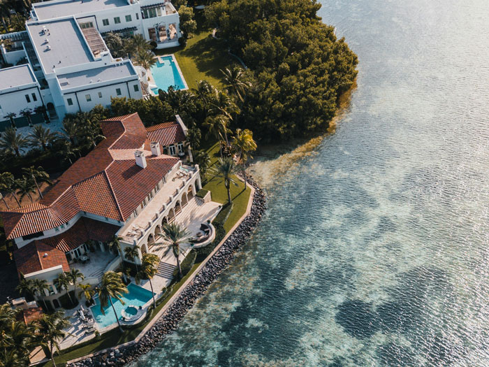 Aerial view of a luxurious waterfront estate, symbolizing massive fortune inheritance and family conflict.