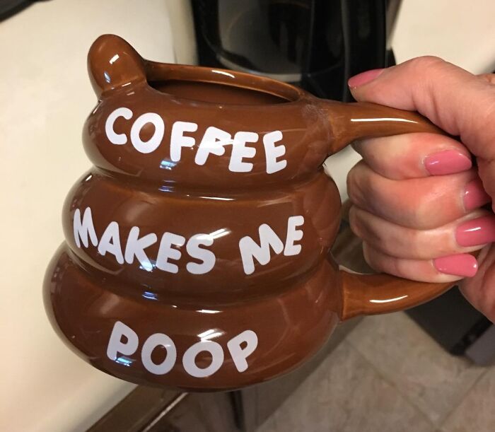 A novelty mug shaped like poop with the text &ldquo;Coffee makes me poop,&rdquo; showcasing toilet humour.