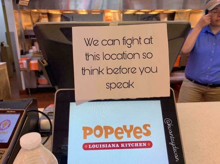 Popeyes counter with humorous sign about speaking, illustrating random internet humor.