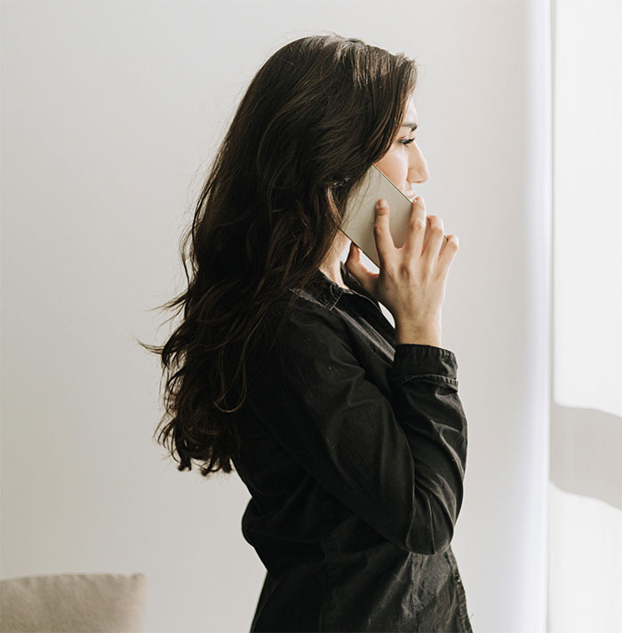 A concerned mother on the phone, discussing sleepover safety after finding a camera in her daughter's friend's room.