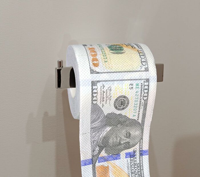 Roll of toilet paper printed with $100 bills as a play on toilet humour.