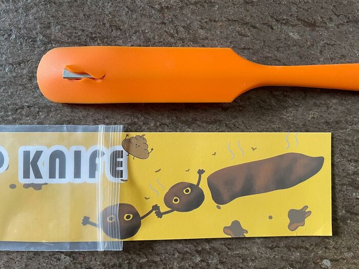 Orange plastic utensil with humorous cartoon poop illustration, related to toilet humour.