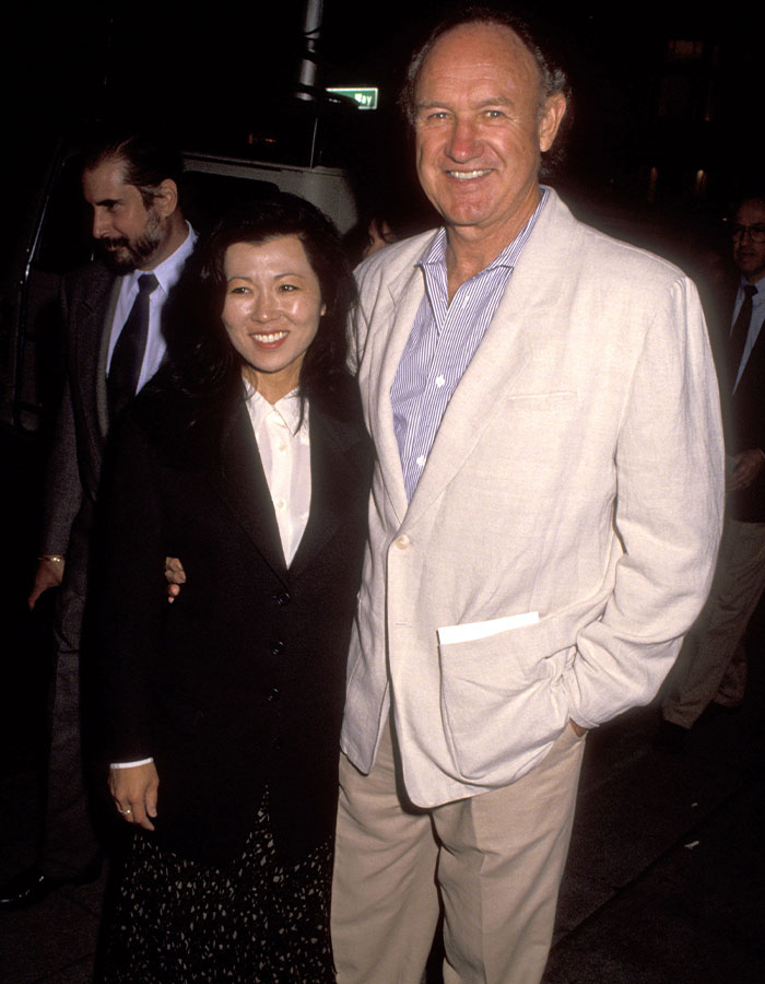 Man and woman smiling together at an event; SEO keyword: Gene Hackman.