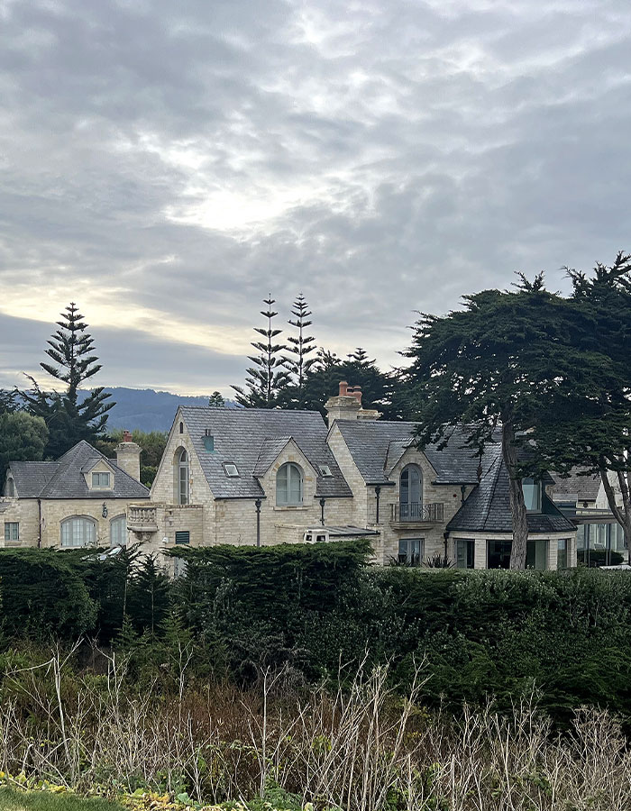 Stone house surrounded by trees under a cloudy sky, related to Gene Hackman in recent news.