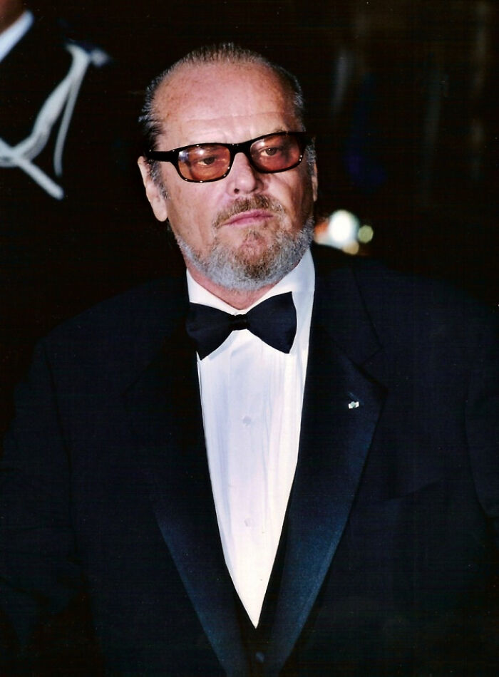 A man in a tuxedo and glasses attends a formal event, illustrating random facts about world fashion events.