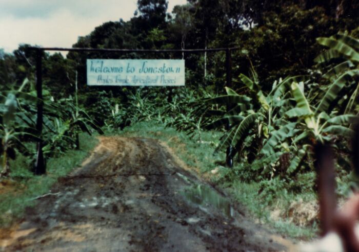 Entrance to Jonestown with a sign amidst greenery, illustrating one of the cool Wikipedia topics to explore.