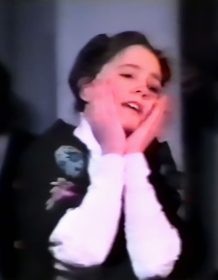 Young girl with hands on cheeks, smiling, dressed in floral embroidered clothing, linked to uncovered photos of Kate Middleton.