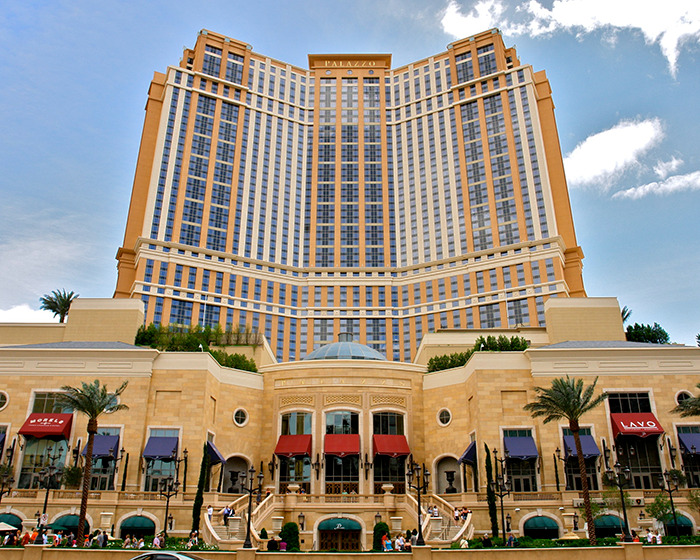 Casino building exterior under a clear blue sky, featuring a grand facade with tall windows and ornate details.