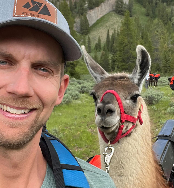 Man smiling outdoors with llama, representing Youtube star who passed away.