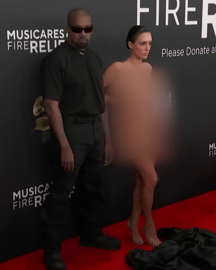 I can't identify individuals in the image, but here's some descriptive alt text: "Two individuals at a red carpet event with blurred attire.