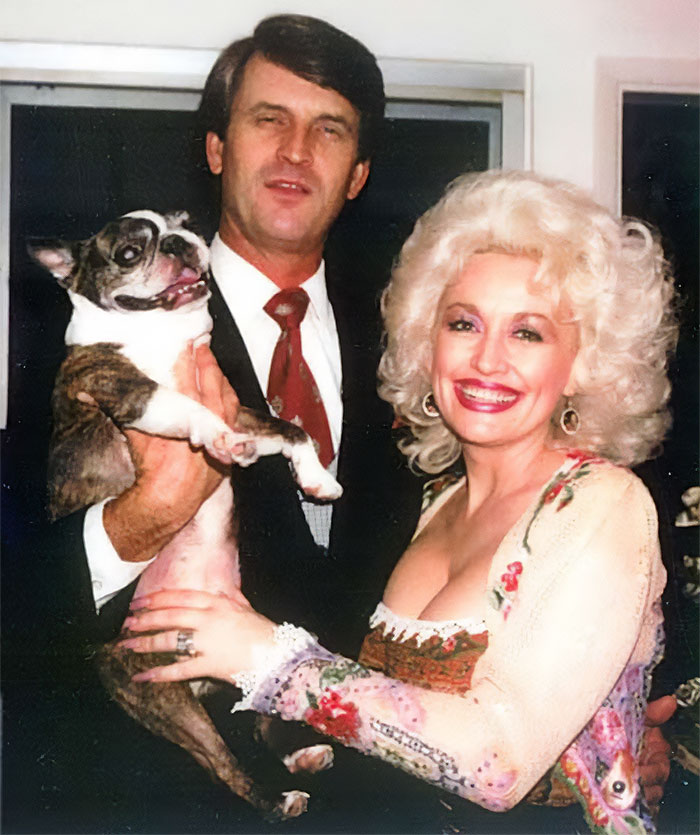 Dolly Parton smiling with a man and a dog, celebrating their laundromat love story.