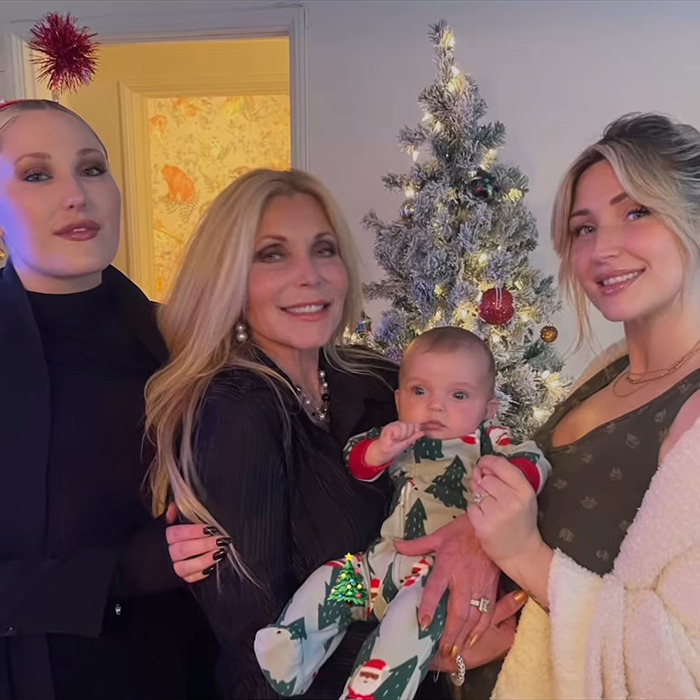 Pamela Bach with family in front of a decorated Christmas tree, celebrating together.