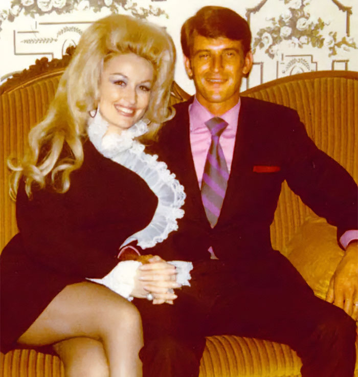 Dolly Parton and Carl Thomas Dean seated together, smiling, showcasing their famous love story.