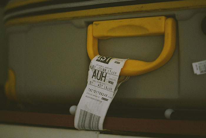 Suitcase with a yellow handle and airport luggage tag, symbolizing Egypt trip preparation.