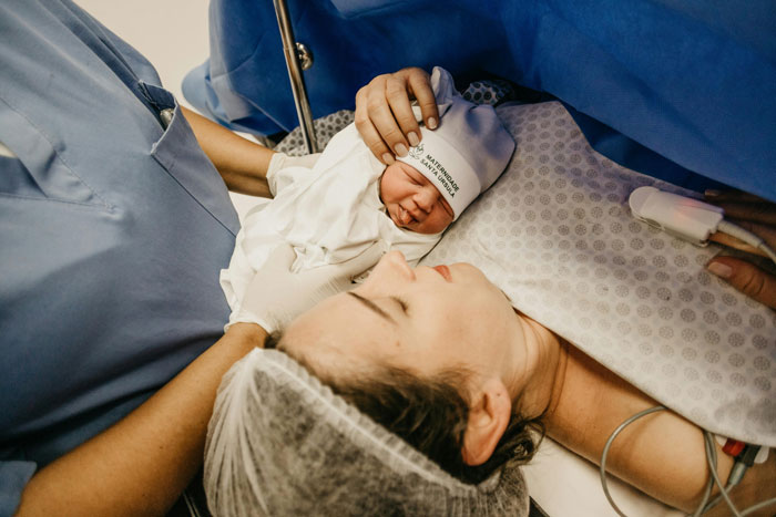 Newborn baby and mother in a hospital setting after birth, emphasizing family.