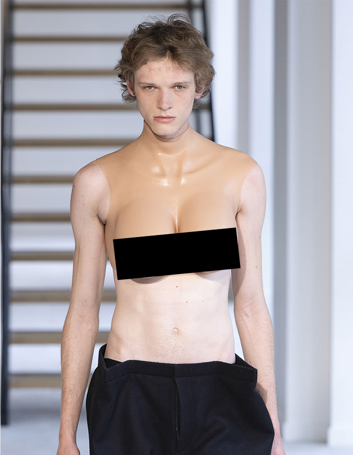 Male model in bold top resembling female chest at Paris Fashion Week.