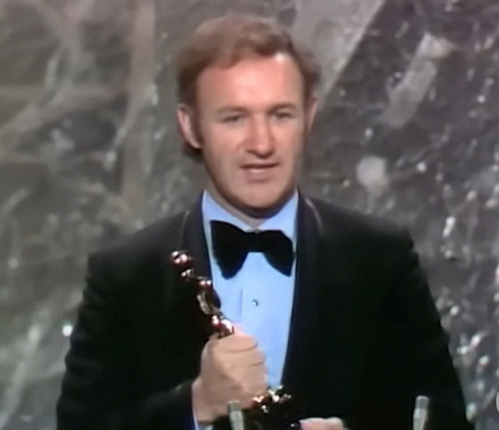 Man in a tuxedo holding an award on stage, related to medical examiner&rsquo;s theory on broken heart-type thing.