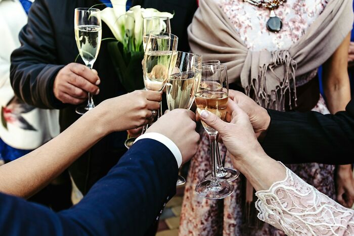 Guests clinking glasses in a wedding celebration, capturing a moment before an objection from the guests.