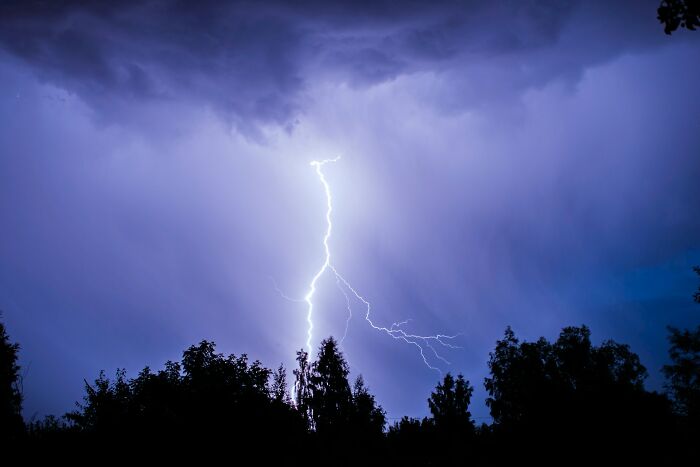 A bolt of lightning illuminates the dark sky, symbolizing unexpected wedding objections amidst stormy weather.