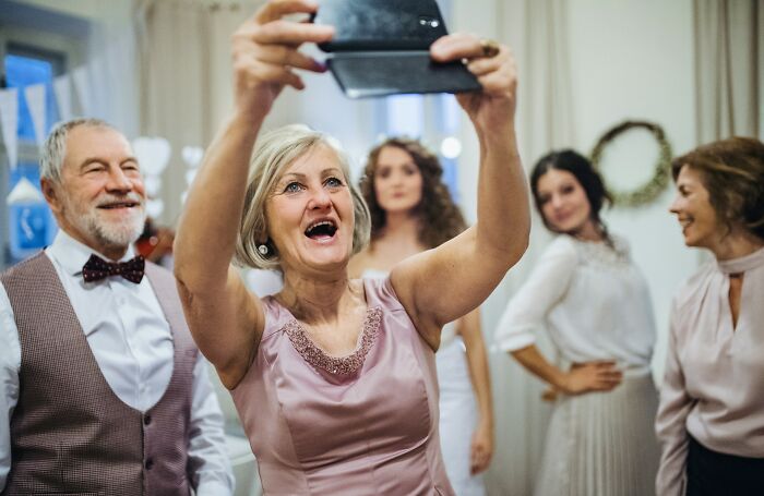 Guests enjoying a wedding, taking a selfie together.