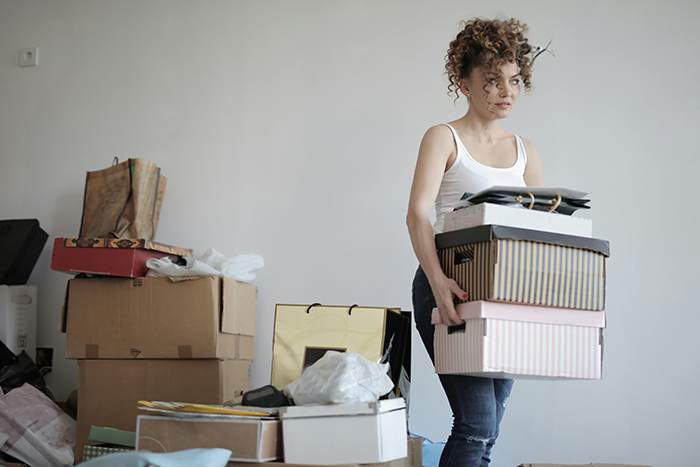 Woman quietly packing boxes, planning an exit after discovering infidelity.