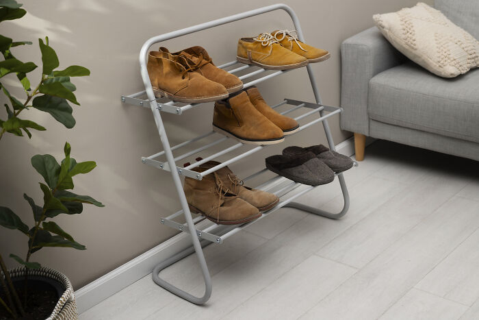 Shoe rack by a sofa, showcasing cleaning hacks impact in tidy living area.