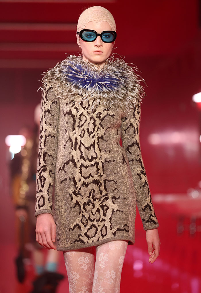 Model wearing an animal print dress and blue goggles at Paris Fashion Week debut.