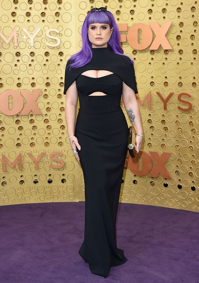 Purple-haired individual in a black dress on a red carpet, illustrating dramatic weight loss transformation.