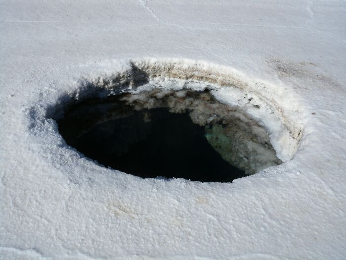 Ice hole formation on a snowy surface, intriguing for cool Wikipedia articles enthusiasts.