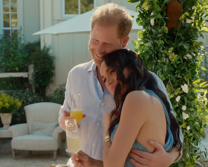 Couple enjoying drinks outdoors, surrounded by greenery, amidst ongoing controversies involving a show.