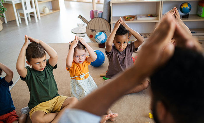 Children in a daycare setting participating in an interactive group activity led by a teacher.