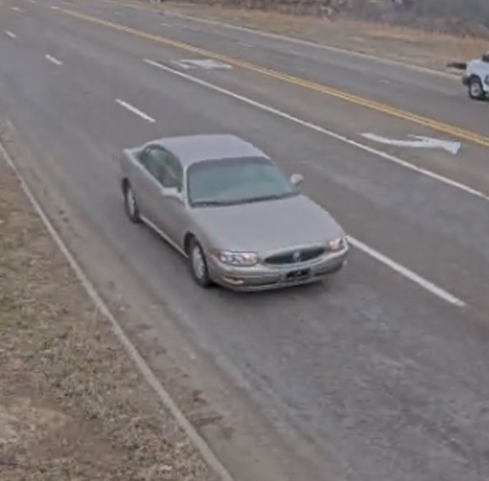 Silver car traveling on a wide, empty road, connected to a 95-year-old woman's mysterious disappearance.