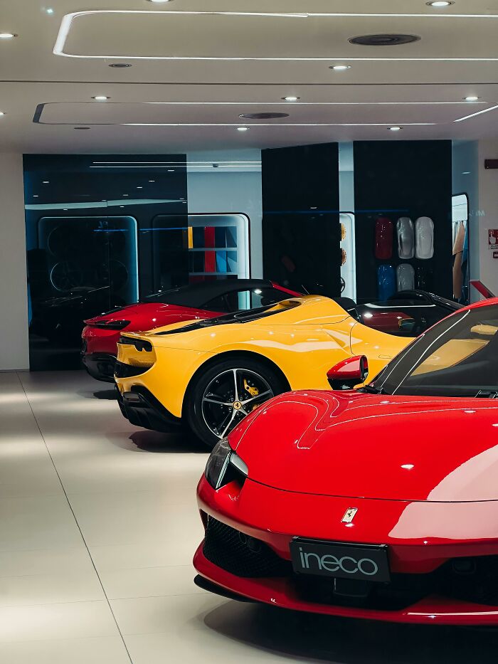 Luxury cars in a showroom under bright lighting, showcasing sleek and professional automotive design.