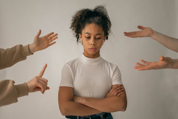 Person standing with crossed arms surrounded by gesturing hands, illustrating a cool Wikipedia article topic.