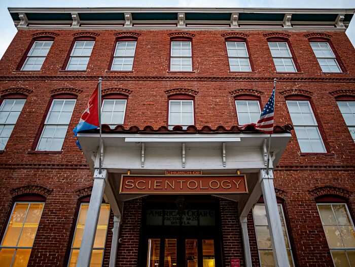 Exterior view of the Church of Scientology building with flags, relating to cool Wikipedia articles.