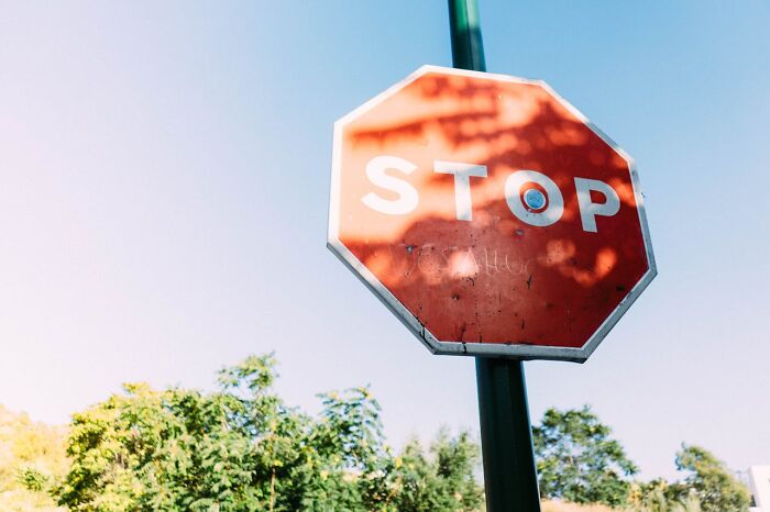 A faded stop sign against a clear blue sky, hinting at random facts about the world.