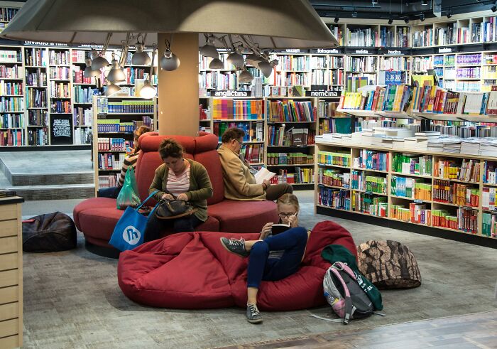 People reading in a cozy bookstore, surrounded by valuable memberships and a variety of books.