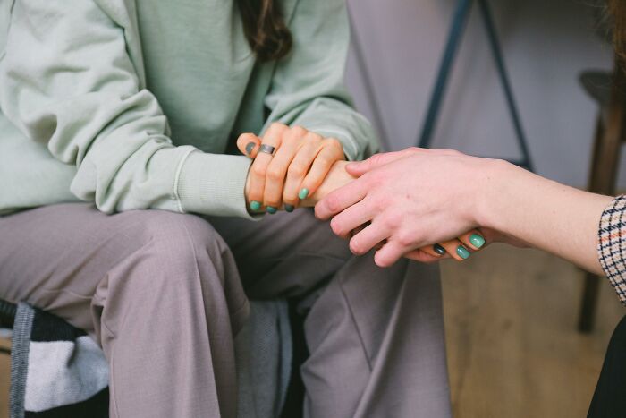 Two people holding hands, symbolizing valuable memberships and support.