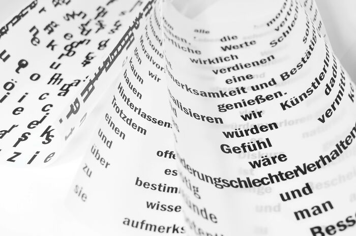 Curved papers displaying text in various languages, highlighting linguistic diversity.