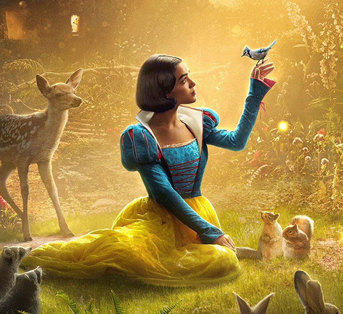 Snow White in the forest surrounded by animals, holding a bluebird, in a Disney scene.