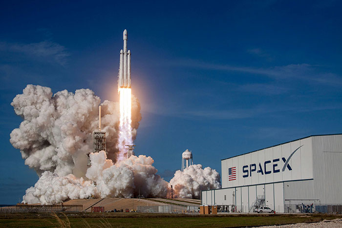 SpaceX rocket launch with cloudy sky backdrop, linked to delayed rescue of stranded astronauts.