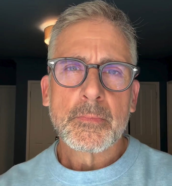 Man with glasses and beard in a light blue shirt, in bright room, helping teen fire victims.