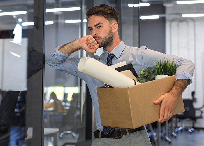 Employee carrying box of office items, reflecting on an experience with a difficult female boss.