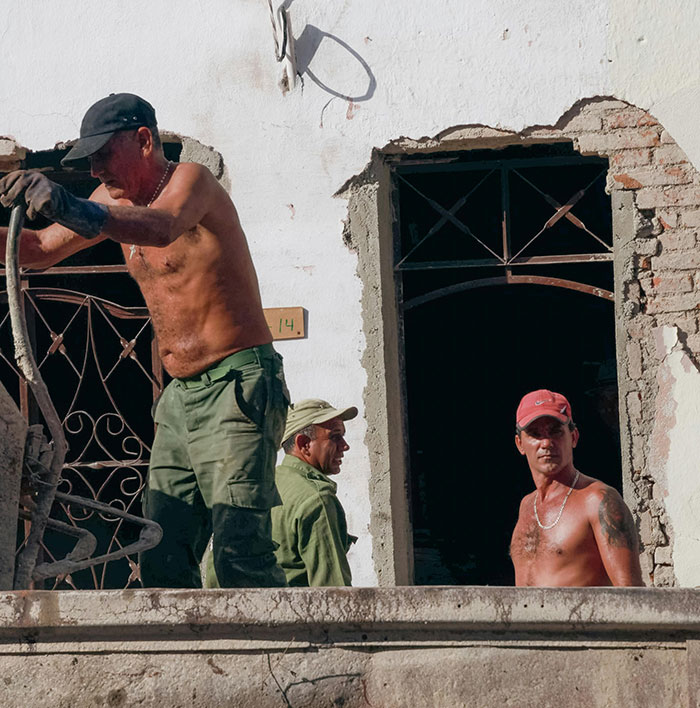 Shirtless male workers in construction site advocating topless work equality.